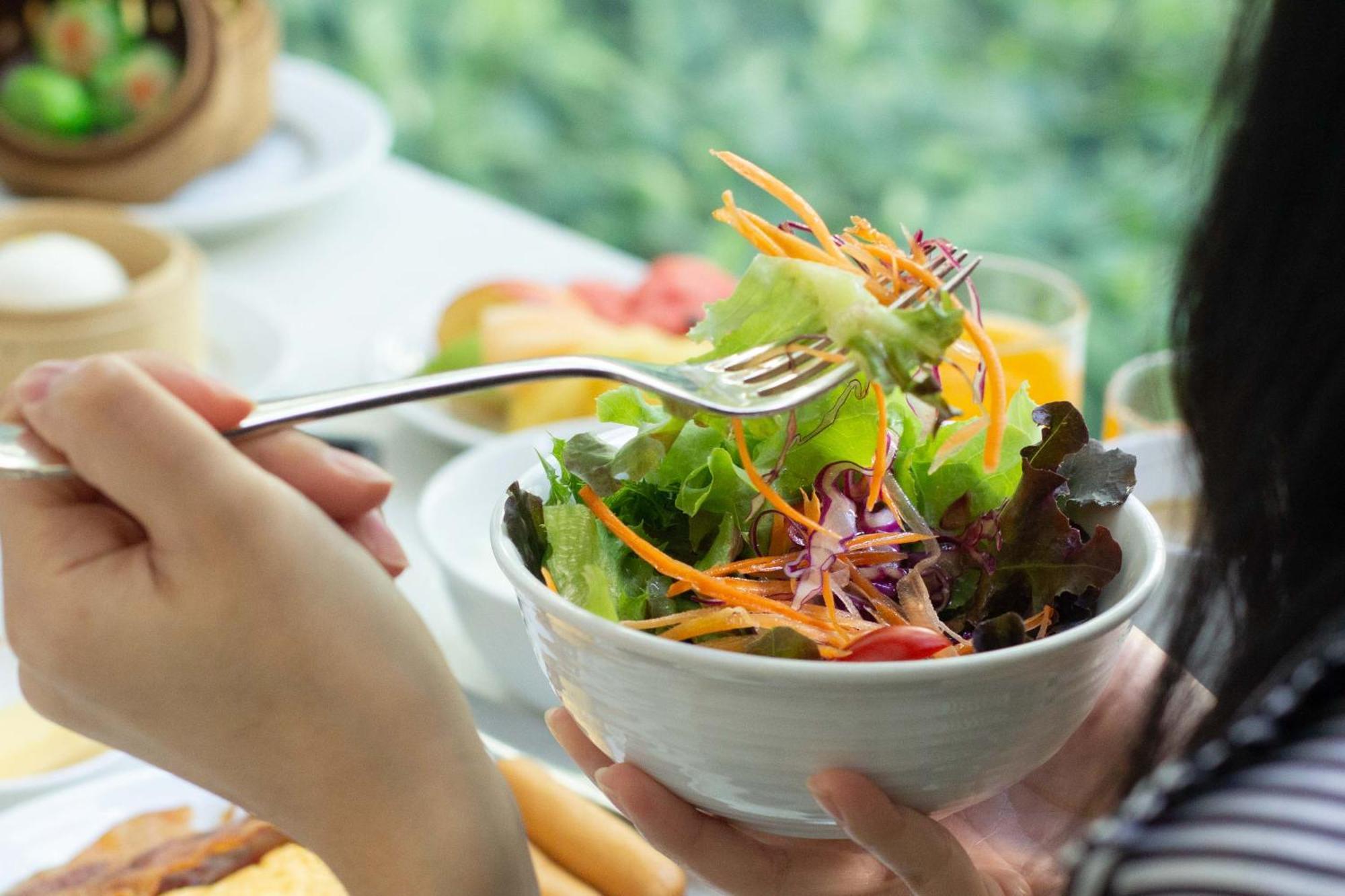 Pullman Bangkok King Power Hotel Exterior foto A woman eating a salad